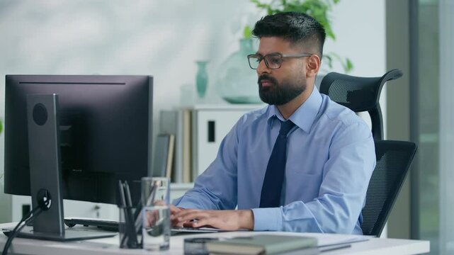 Indian businessman Arabian business man ethnic male worker guy professional entrepreneur working in office typing computer checking documents work process focused busy job online at workplace table