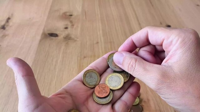 Manos de hombre contando dinero en met&aacute;lico llegar a fin de mes