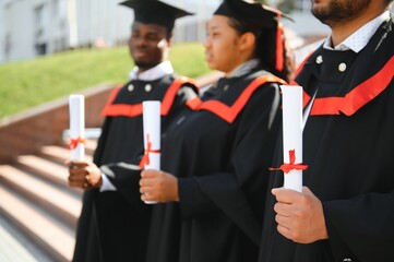 Diverse international students with diplomas at university campus