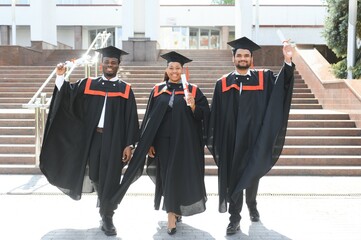 Diverse international students with diplomas attending graduation ceremony, happy multiracial group...