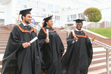 Diverse international students with diplomas attending graduation ceremony, happy multiracial group...