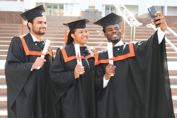 Diverse international students with diplomas attending graduation ceremony, happy multiracial group...