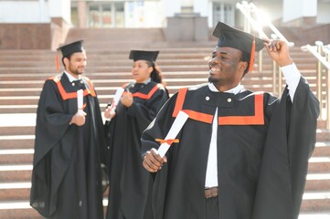 smiling african american graduated student showing diploma