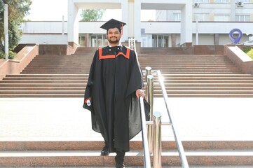 Portrait of happy man, graduation or student in university campus