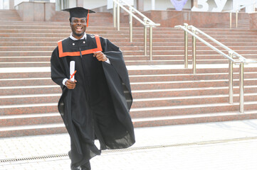 smiling african american graduated student showing diploma