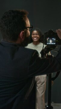 Vertical shot of pleased unrecognizable filming director clapping after African American actress finishing acting