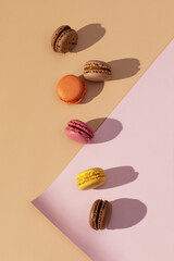 Colorful Macarons on Pastel Background, Flat Lay Dessert Photo, French Macarons with Shadows, Top View on Pink and Beige, hard light