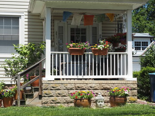 The house with flowers  outside decorate the small porch.