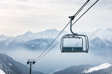 Obraz premium Ski lift ascends through snowy mountains under clear blue sky at winter sunset near popular ski resort