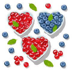 Heart-shaped bowls with cherries and blueberries, isolated on black