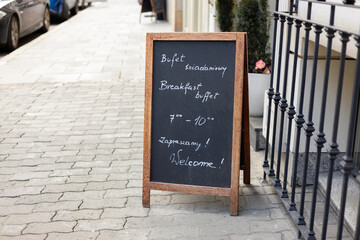 Cafe sign with text in an old European city. Restaurant sidewalk chalkboard sign board. Old Black Signboard on the street. Blank store signage sign design