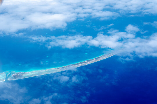 Aerial view of the Tuamotus atoll in French Polynesia with clouds