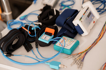 Polysomnography Setup with Electrodes and Sensors on a Table. Blue and Black Medical Devices,...