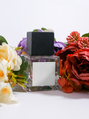 Perfume bottle mockup with plain white label, flowers background decoration, studio scene