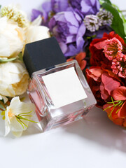 Perfume bottle mockup with plain white label, flowers background decoration, studio scene