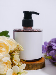 soap bottle with plain white label on bouquet of flowers scene
