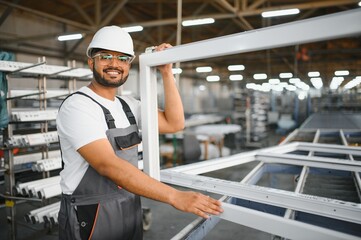 Young Indian male engineer wearing safety workwear standing in the factory