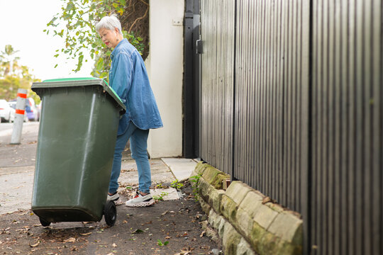 woman taking out wheelie bin