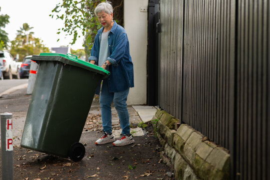 woman taking out wheelie bin