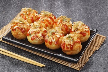 Takoyaki is a typical Japanese snack in the form of small balls made from wheat flour dough and filled with pieces of octopus.