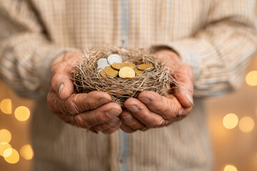 Elderly person holding a small nest egg with dollar coins inside, concept of retirement savings,
