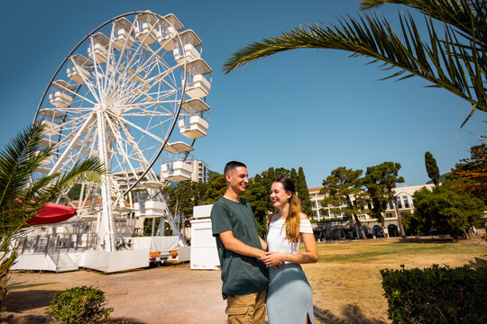 Romantic Couple by the Ferris Wheel on a Summer Day
