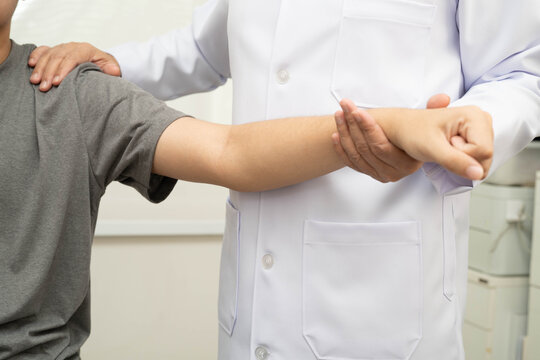 Physical therapy, Asian therapist doctor treat perform pain young man in hospital.