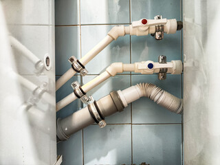 The plumbing installation features pristine white pipes and valves set against a beautifully tiled...