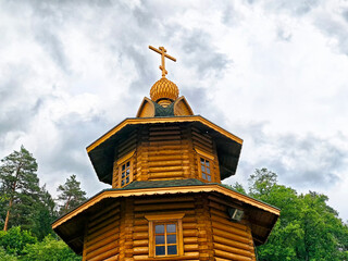The wooden church stands proudly amidst a sea of lush, green trees, its elegant structure framed by...