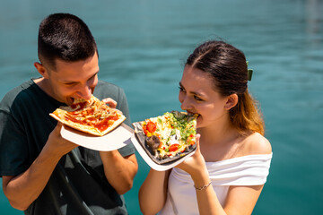 Couple Eating Pizza  by the Sea Shore on Summer Holiday