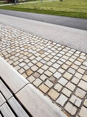 Modern gardening and patio design: a mix of paving stones, paved path, wooden benches, and artificial turf