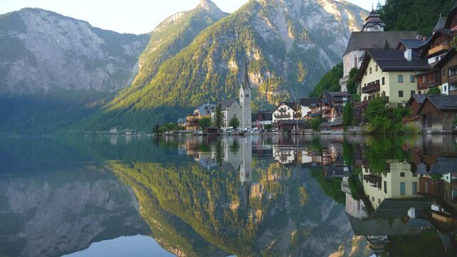 Idyllic Hallstatt with reflection in the lake water - old town, Austria. Big Panorama - 4K Video.