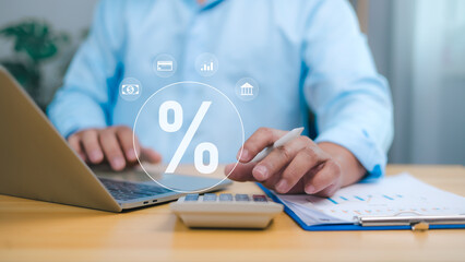 Businessman using laptop and calculator to manage finance, tax rates, banking interest, accounting, investments. Financial data analysis and interest rate percentage representing economic strategy.