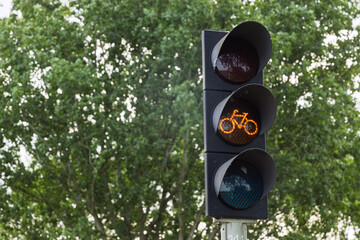 A traffic light in the Netherlands showing an illuminated orange bicycle signal, indicating...