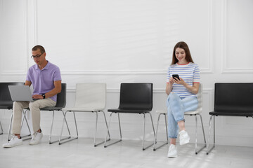 Man and woman waiting for appointment indoors