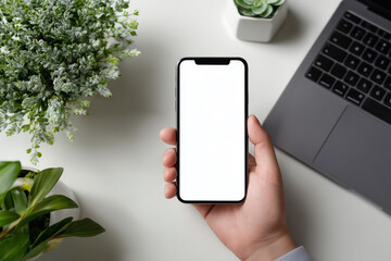 Hands holding smartphone with white screen at clean modern desk