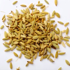 Close-up of aromatic fennel seeds scattered on plain surface for culinary use on white background