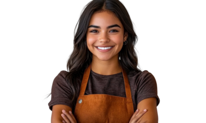 Smiling young woman in brown apron posing confidently with arms crossed, representing professionalism and warmth in culinary or service industries