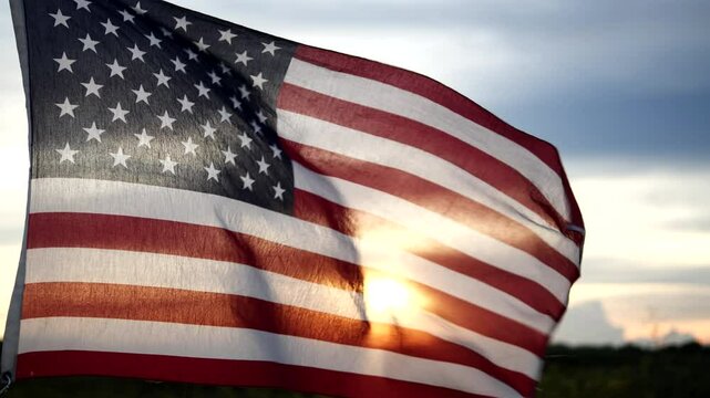 4th of July, Happy Independence Day. American flag is waving in sky against sunset, with sunrise in backdrop. Concept USA, Freedom, Celebration, Fourth of July, Independence Day, Veterans Day, Holiday