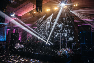 A festive New Year celebration setup with a stage beautifully illuminated by dynamic lighting and...