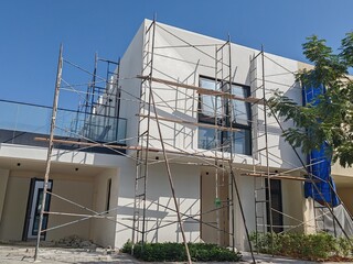 Under Construction luxurious House Or Villa's outdoor view.
Exterior View Of 02 Story Incomplete House With Modern Design.
White Color UnComplete Villa Structure with Erected Scaffolding Pipes around.