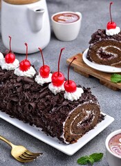 Soft and fluffy black forest roll cake with strong delicious chocolate flavour, rolled with...