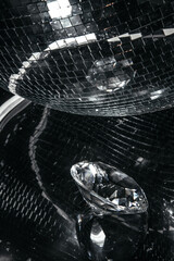 Disco ball reflections create a striking pattern across a shiny surface while a sparkling diamond...