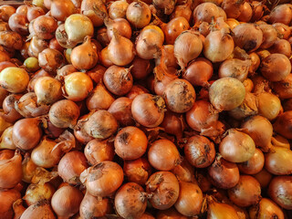 Obraz premium Fresh onions forming a large pile at the market