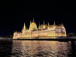 Fototapeta premium Le Parlement à Budapest de nuit, depuis le Danube