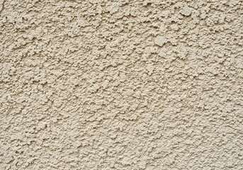 Rustic Beige Stucco Wall Texture. Close-up of a rugged light brown building exterior. This highly tactile architectural surface offers an organic, earthy backdrop, conveying durability and.