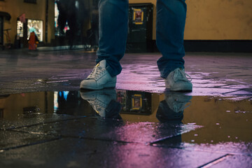 A man standing next to a puddle