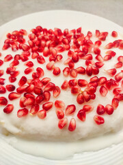 Delicious white cake decorated with fresh pomegranate seeds for birthday