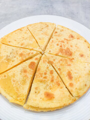Delicious quesadilla slices resting on white plate, appetising mexican dish