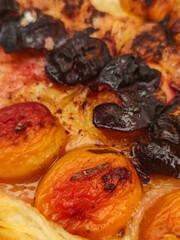 Apricot halves baking in syrup with burnt herbs and spices